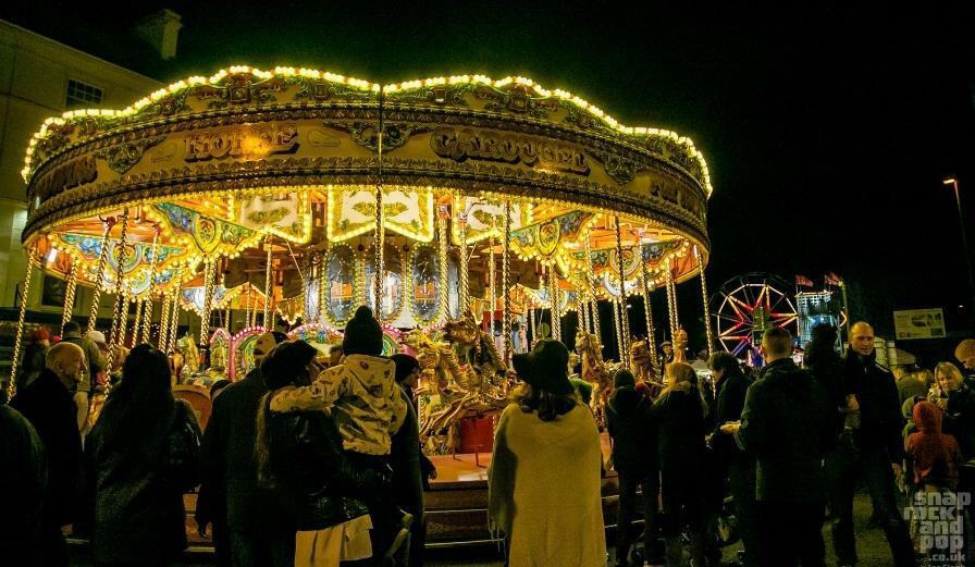 Photo of carousal during Victorian Christmas Market during the night with people watching