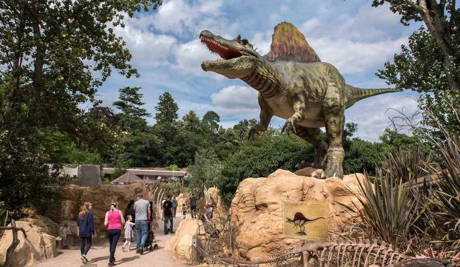 Photo of dinosaur at West Midland Safari Park with visitors walking through the exhibit