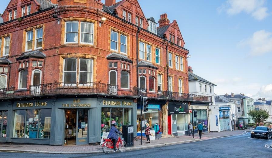 Photo of high street in Malvern with shoppers and cyclists present in the photo