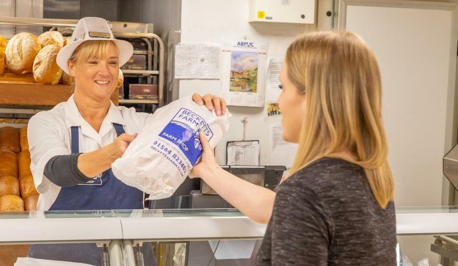 Photo of staff member at Becketts Farm handing over bag to customer