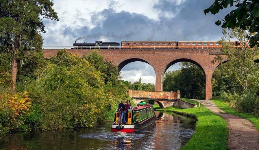 Photo of viaduct in Kidderminster with steam train and canal boat in the frame
