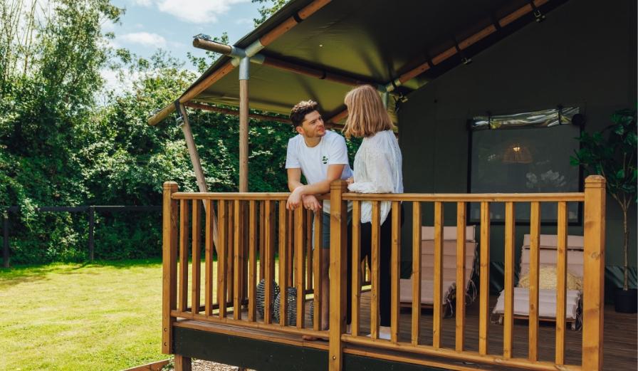 Visitors standing on the decking of a Safari Tent