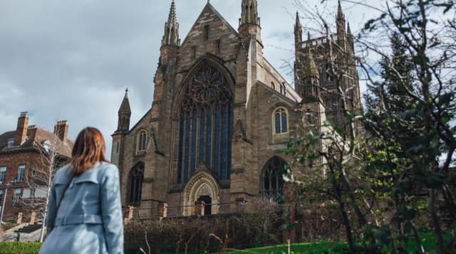 A photo Worcester Cathedral with a women looking up towards the windows
