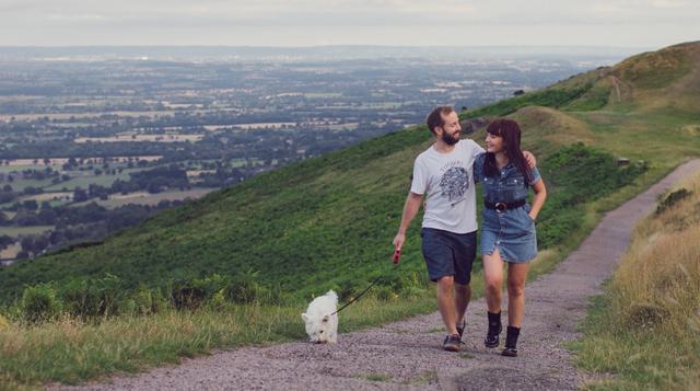 Photo of a couple walking across the Malvern Hills with a dog