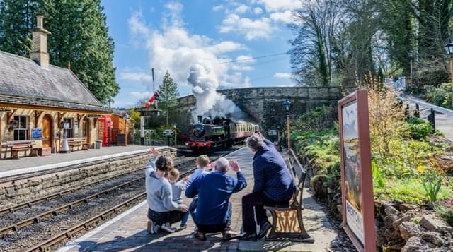 Photo of a family waving towards at steam engine at Arley Station Severn Valley Railway