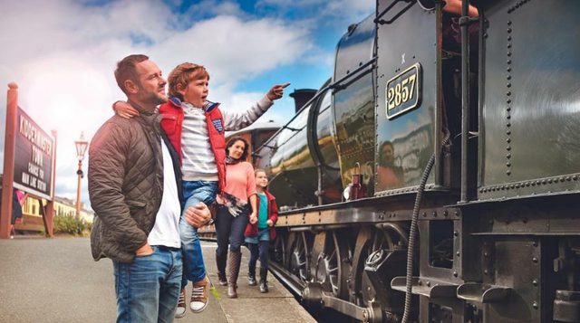 Photo of adult and younger child standing on platform at Severn Valley Railway