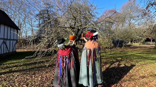 Wassail procession leaders blue sky with T house