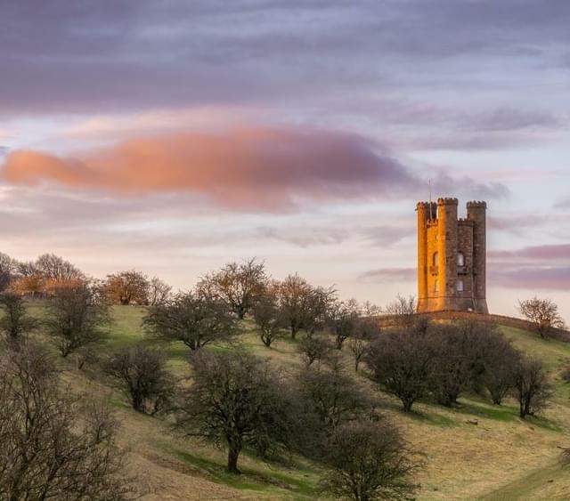 Photo of Broadway Tower on the hill in the distance with a wintery background