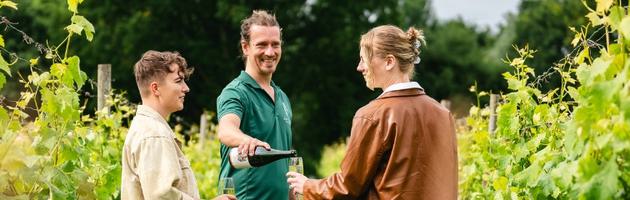 Two visitors on a vineyard tour at Astley Vineyard Sampling wine